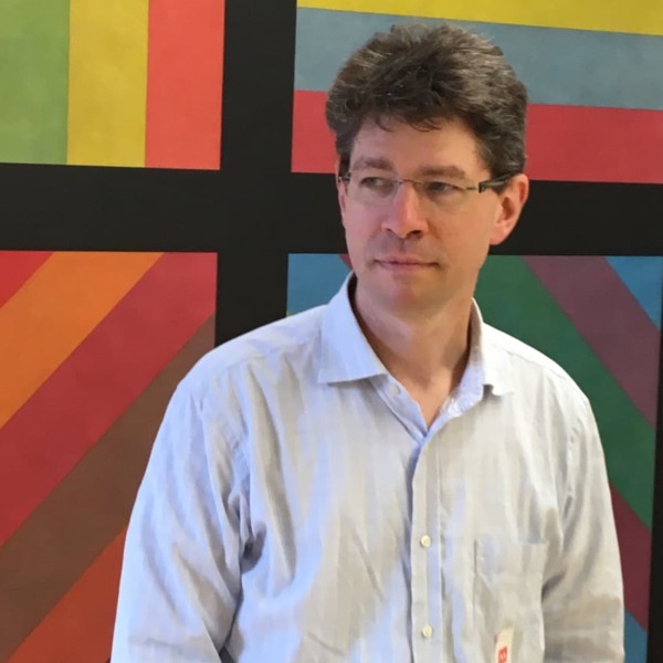 man in white shirt standing in front of Sol Lewit artwork