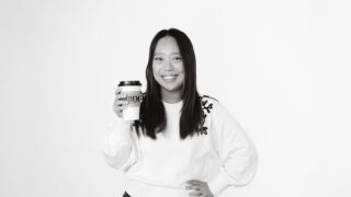 Student holding takeout coffee cup