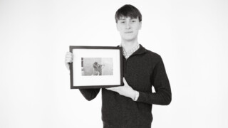 Student holding a framed photograph