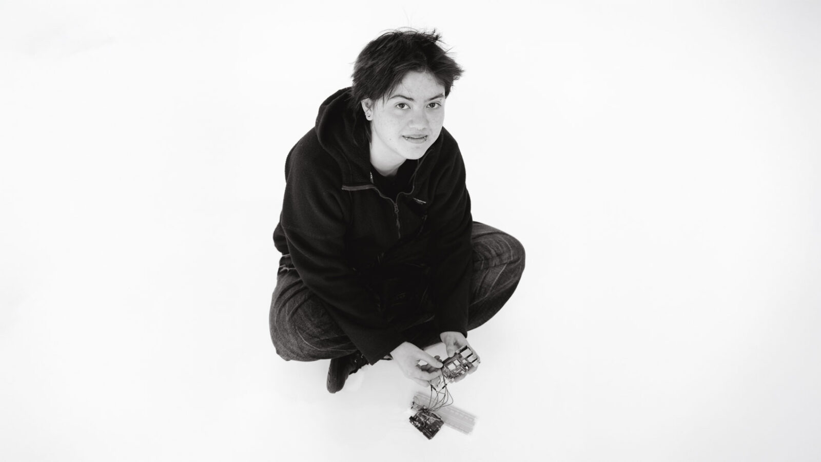 Student sitting on the ground with electronics