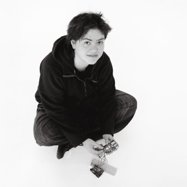 Student sitting on the ground with electronics