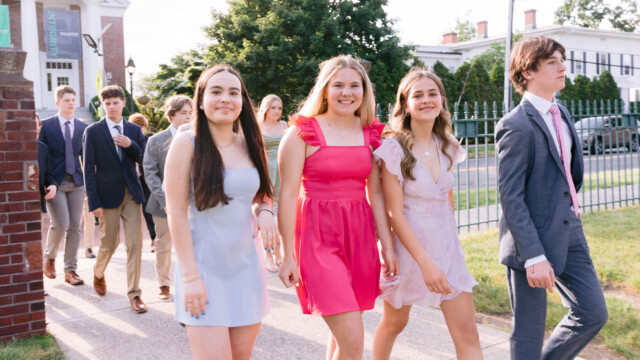 students dressed nicely walking on a sidewalk