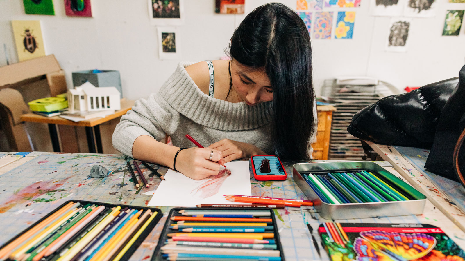student artist using colored pencils in classroom