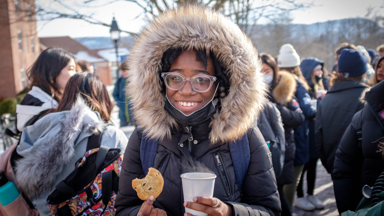 girl in hooded coat with cookie
