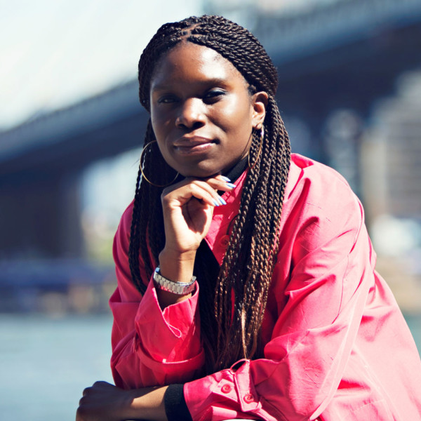 woman in front of a bridge over the East River in NYC