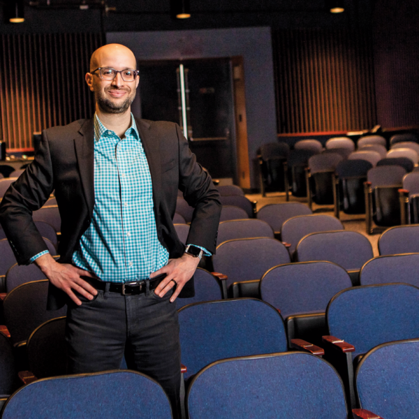 man standing in row of seats in theater